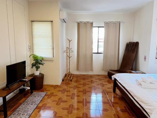 a bedroom with a bed and a flat screen tv at inghome & guesthouse in Chiang Mai