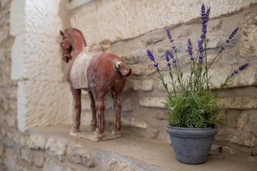 a statue of a chicken sitting next to a plant at Hôtel Le Square in Saint-Pierre-dʼOléron