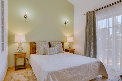 a hotel room with a bed and two lamps at Espargosa Monte de Baixo & Art in Castro Marim