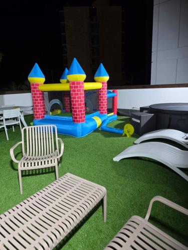 a playground with a table and a bench and grass at Briza in Netanya