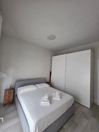 a bedroom with a white bed with shoes on it at Casa Dream - Milan in Cesano Boscone