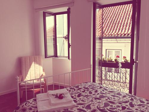 アヴェイロにあるCasa dos Pátios IIのベッドルーム1室(ベッド1台、窓、椅子付)