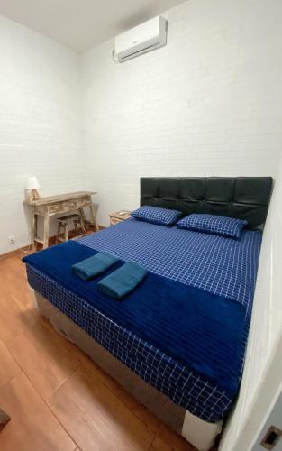 a bed with blue sheets in a room at D' Jati Homestay in Ungasan