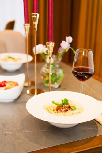 a table with a plate of food and a glass of wine at SIA Resort and SPA in Tsaghkadzor