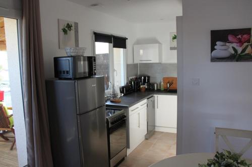 a kitchen with a stainless steel refrigerator with a microwave at ENTRE LOIRE ET CHER "Le Sologn'Eau" Gîte & SPA Privatif in Tour-en-Sologne