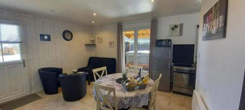 a kitchen and living room with a table and chairs at ENTRE LOIRE ET CHER "Le Sologn'Eau" Gîte & SPA Privatif in Tour-en-Sologne