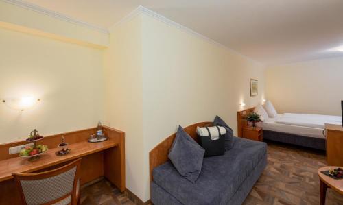 a hotel room with a couch and a bed at Moselstern Hotel Brixiade &Triton in Cochem