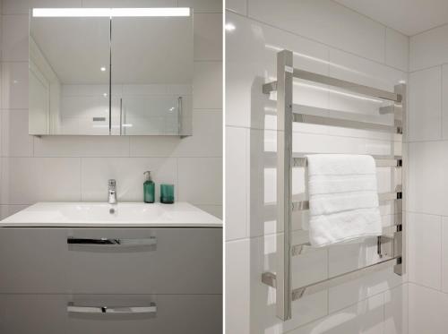 Un baño blanco con lavabo y espejo. en Top-floor SoFo flat with balcony, en Estocolmo