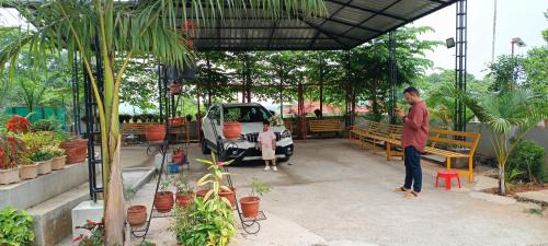 a man standing under a pavilion in a garden at Pauls Retreat Wayanad in Wayanad