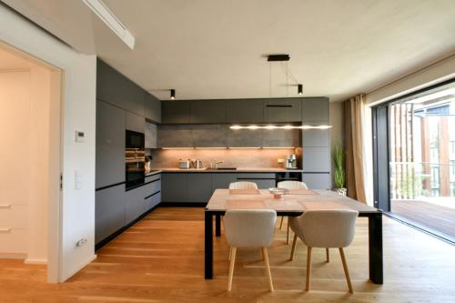 a kitchen with a dining room table and chairs at MOLO LIPNO RESIDENCE in Lipno nad Vltavou