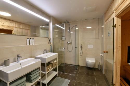 a bathroom with two sinks and a shower at MOLO LIPNO RESIDENCE in Lipno nad Vltavou