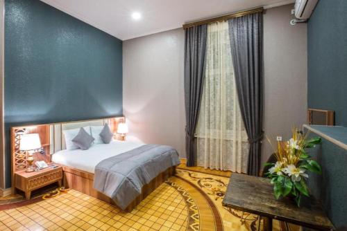 a hotel room with a bed and a window at Prestige Lodge Formula1 in Baku