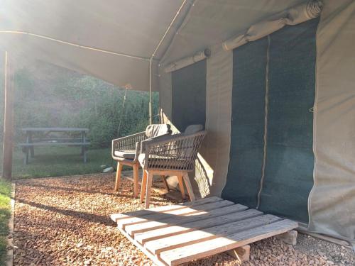 a tent with a bench and a picnic table at The Calitzdorp Station in Calitzdorp