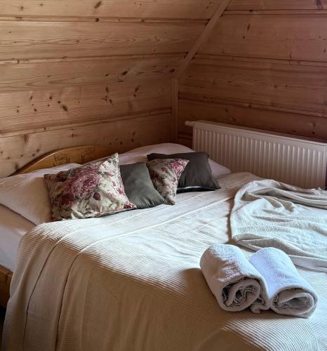 a bed with towels on it in a room at Domki w Białce pod Basenami, 50 m od term i wyciągów in Białka Tatrzanska