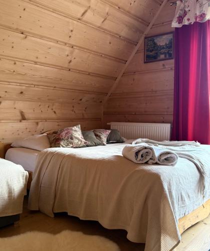 a bedroom with two beds in a log cabin at Domki w Białce pod Basenami, 50 m od term i wyciągów in Białka Tatrzanska