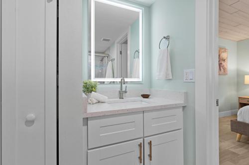 a white bathroom with a sink and a mirror at Sea Dream - Pet Friendly, Located in Siesta Key Village, Steps to Siesta Key Beach! in Bailey Hall