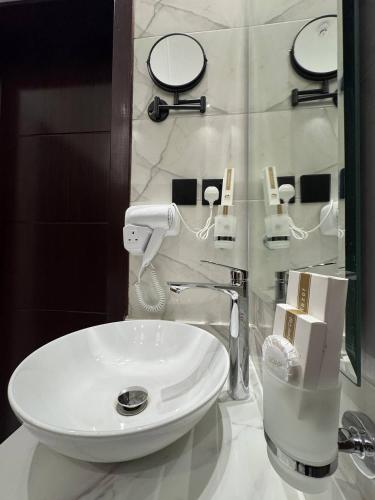 a bathroom with a white sink and a mirror at فندق روابي جاردن إن ابها Rawabi Garden In ABHA Hotel in Abha