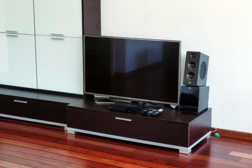 a flat screen tv sitting on top of a dresser at Kümin Lake View by Quokka 360 - with direct access to the lake in Collina d'Oro