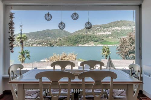 a dining room table with a view of a lake at Kümin Lake View by Quokka 360 - with direct access to the lake in Collina d'Oro