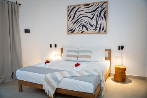 a bedroom with two beds and a painting on the wall at Tamu Tamu Boutique Hotel in Pwani Mchangani
