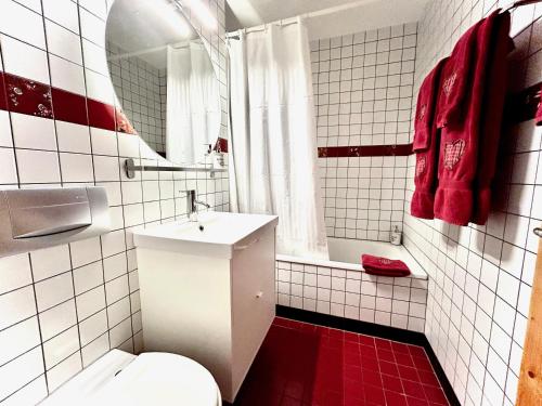 Un baño con inodoro, lavabo y espejo. en Alpine Studio Apartment, en Maloja