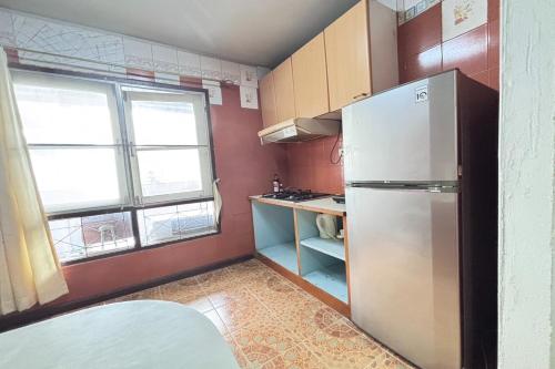 a small kitchen with a refrigerator and a window at Sunshiny-BB Hostel in Bangkok