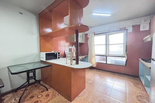 a kitchen with a counter and a table and a microwave at Sunshiny-BB Hostel in Bangkok