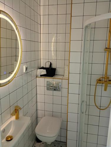 a bathroom with a toilet and a sink and a mirror at Deluxe Apartament z tarasem i parkingiem na wyłączność in Ciechanów