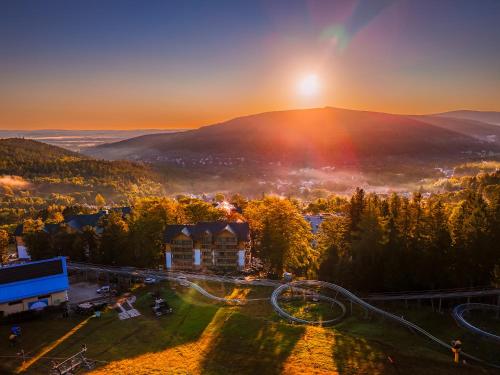 an aerial view of a resort in the mountains with the sunset at Forest Park Resort & SPA in Świeradów-Zdrój