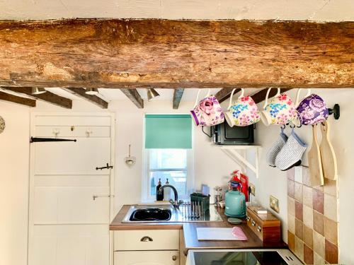 a kitchen with a sink and some pots and pans at Watts Cottage, Cosy 2 bed, historical home in Bexhill