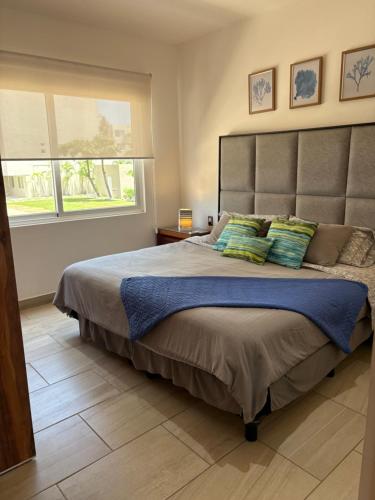 a bedroom with a large bed with green pillows at Depa de lujo en Acapulco diamante con club de playa a pie-Precio especial in Acapulco