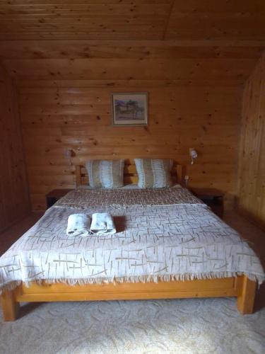 a bedroom with a bed in a wooden cabin at Садиба "ЯНА" in Slavske