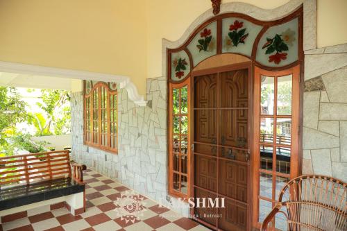 a large wooden door in a room with a tile floor at Lakshmi Ayurveda & Yoga Retreat in Kovalam