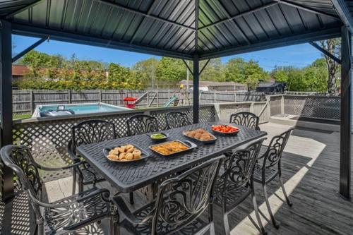 a table and chairs with food on a patio at Heated Pool, Hot Tub, Walk to Town, Games! in South Haven