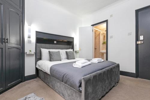 a bedroom with a large bed with two towels on it at Magic Stay Rooms in London