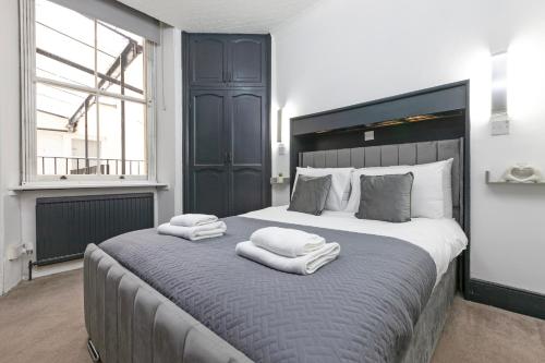 a bedroom with a large bed with towels on it at Magic Stay Rooms in London