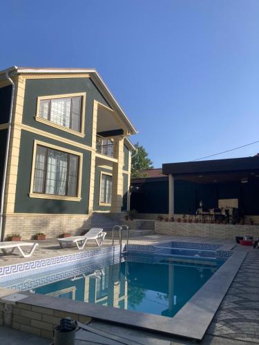 a house with a swimming pool in front of a house at Green Villa in Vǝndam
