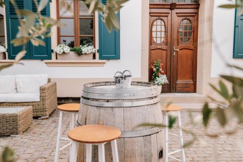 a barrel bar with stools in front of a building at Schmidtburger Hof in Weiler