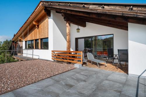 a house with a deck and a patio at Kesselmoos in Nova Ponente