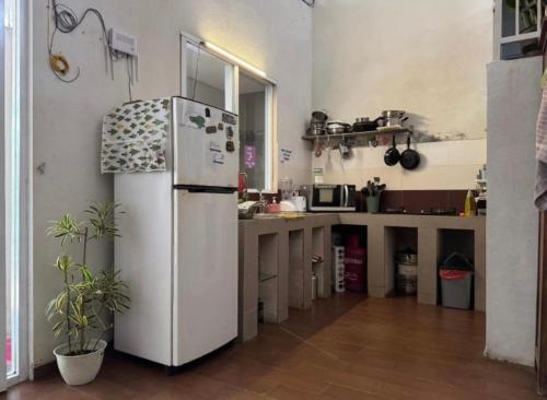 a kitchen with a white refrigerator in a room at D' Jati Homestay in Ungasan