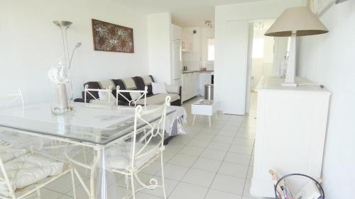 ein weißes Wohnzimmer mit Tisch und Stühlen in der Unterkunft Golfe de saint-tropez a 50 m de la plage in Gassin