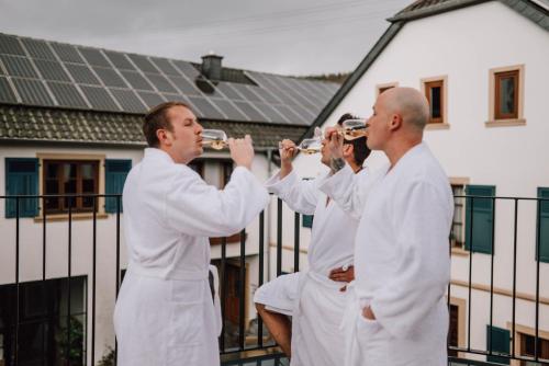 a group of men drinking wine in front of a house at Schmidtburger Hof in Weiler
