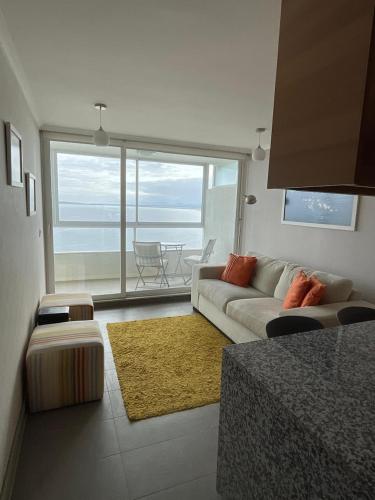 a living room with a couch and a view of the ocean at Stunning views of the Pacific Ocean in Concón