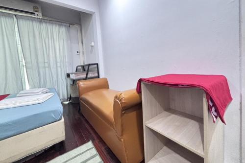 a room with a bed and a couch and a chair at Sunshiny-BB Hostel in Bangkok