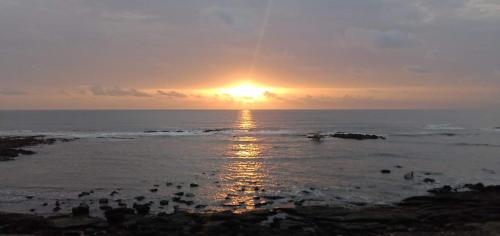 a group of people on the beach at sunset at Paradise Farm Alibaug in Kashid