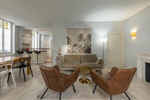 a living room with a couch and chairs and a table at Hôtel Le Square in Saint-Pierre-dʼOléron