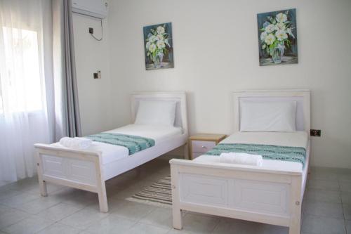 a bedroom with two beds and a window at Subree Luxury Villas- Nyali in Mombasa