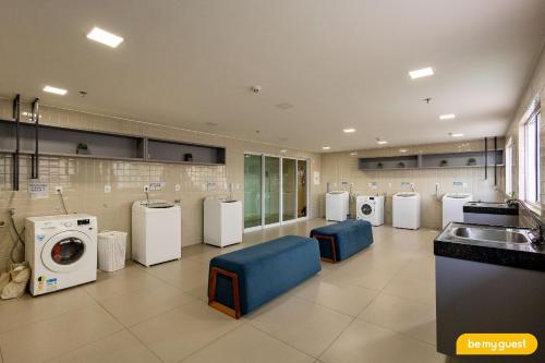 a laundry room with a row of washers and dryers at Design 1 - Sobral in Sobral