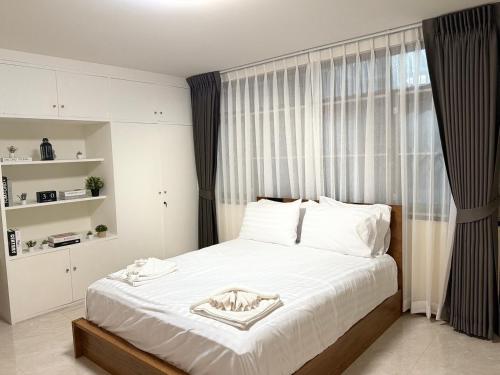 a bedroom with a bed with white sheets and a window at 10MIN 曼谷独栋Chatuchack,Kasetsart精品别墅 MYSTORY HOUSE in Bangkok