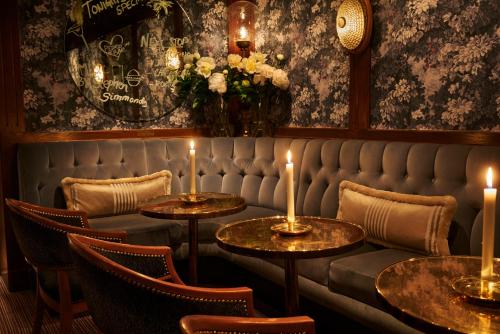 a restaurant with two tables and candles on a bench at Hotel Diplomat Stockholm in Stockholm